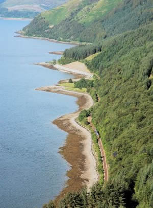 One of the things which is definitely not to be missed during any visit to Lochcarron is a trip on the Kyle of Lochalsh railway line which featured some few years ago as one of Michael Palin's "Great Railway Journeys of the World". The nearest railway station is at Strathcarron, 3 miles from Lochcarron village. From there the line runs to Plockton, Duirinish and Kyle of Lochalsh, hugging the coast-line for much of the way as you can see in this photo.